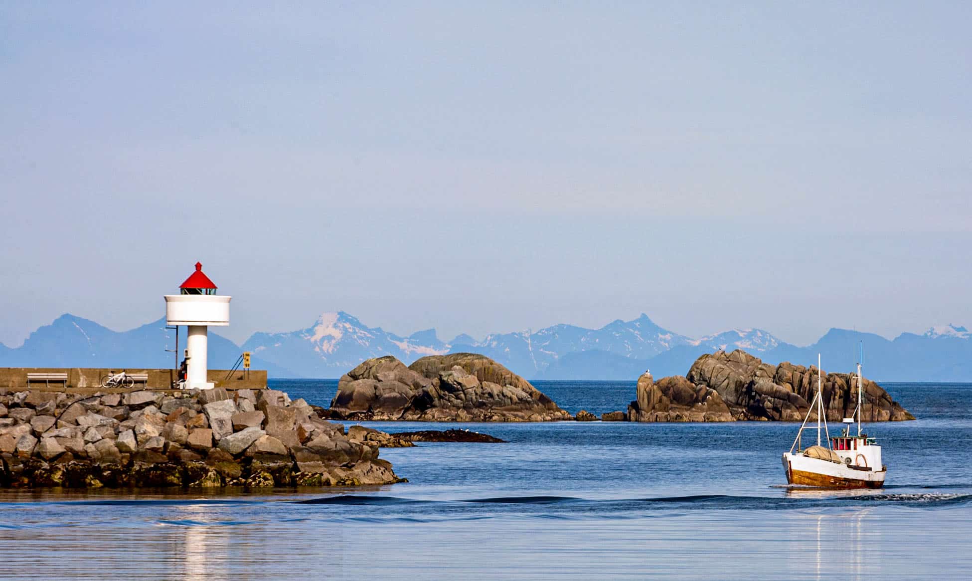 Foto av en fiskebåt og en fyrlykt