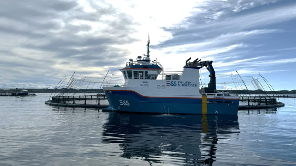 Foto av en båt ved et oppdrettsanlegg